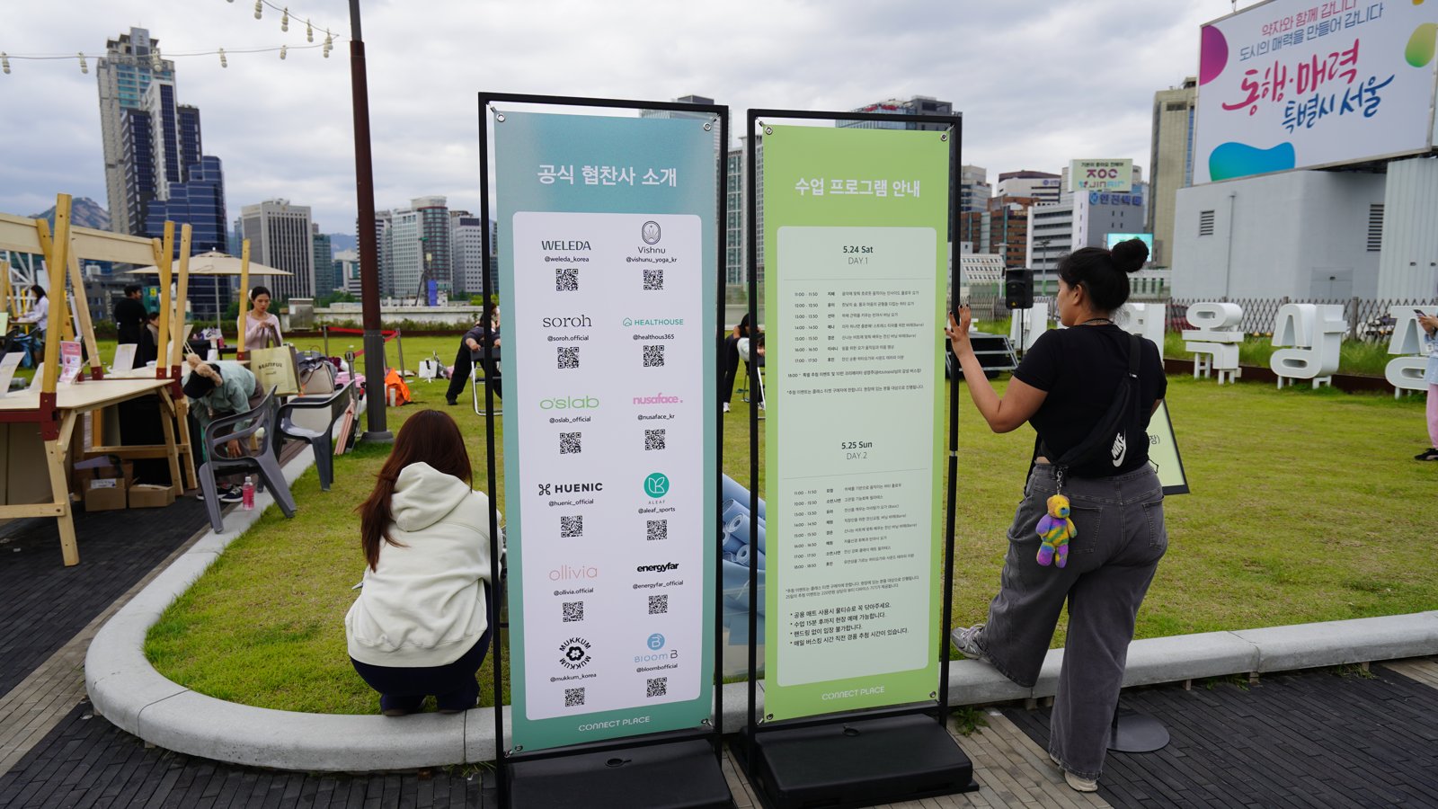 잔디밭 가장자리에 공식 협찬사 소개와 수업 프로그램 안내가 적힌 세로 배너 두 개가 서 있다
