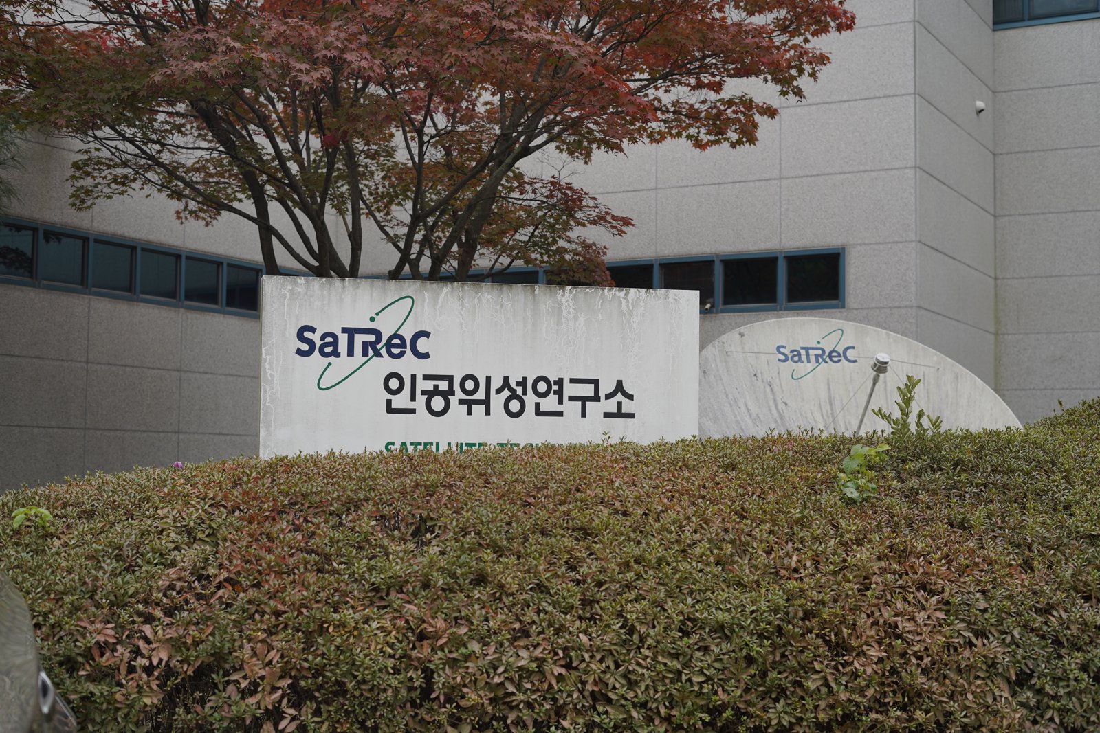 붉게 물든 나무 아래 SaTReC 인공위성연구소라고 적힌 표석이 서 있다