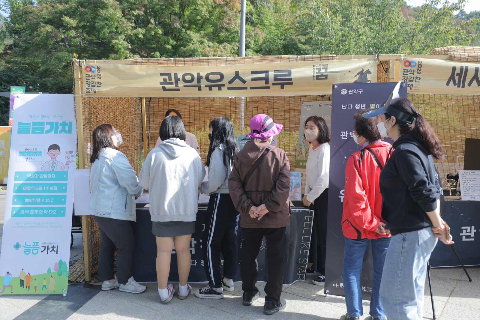 대나무 발을 두른 청년 부스 앞으로 방문객들이 줄지어 지나가고 있다