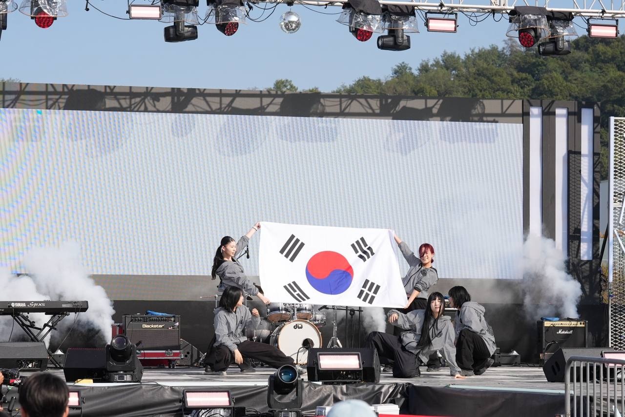 LED 화면 앞 무대에서 회색 의상의 출연진이 태극기를 펼쳐 들고 무대 양옆으로 연기가 피어오른다