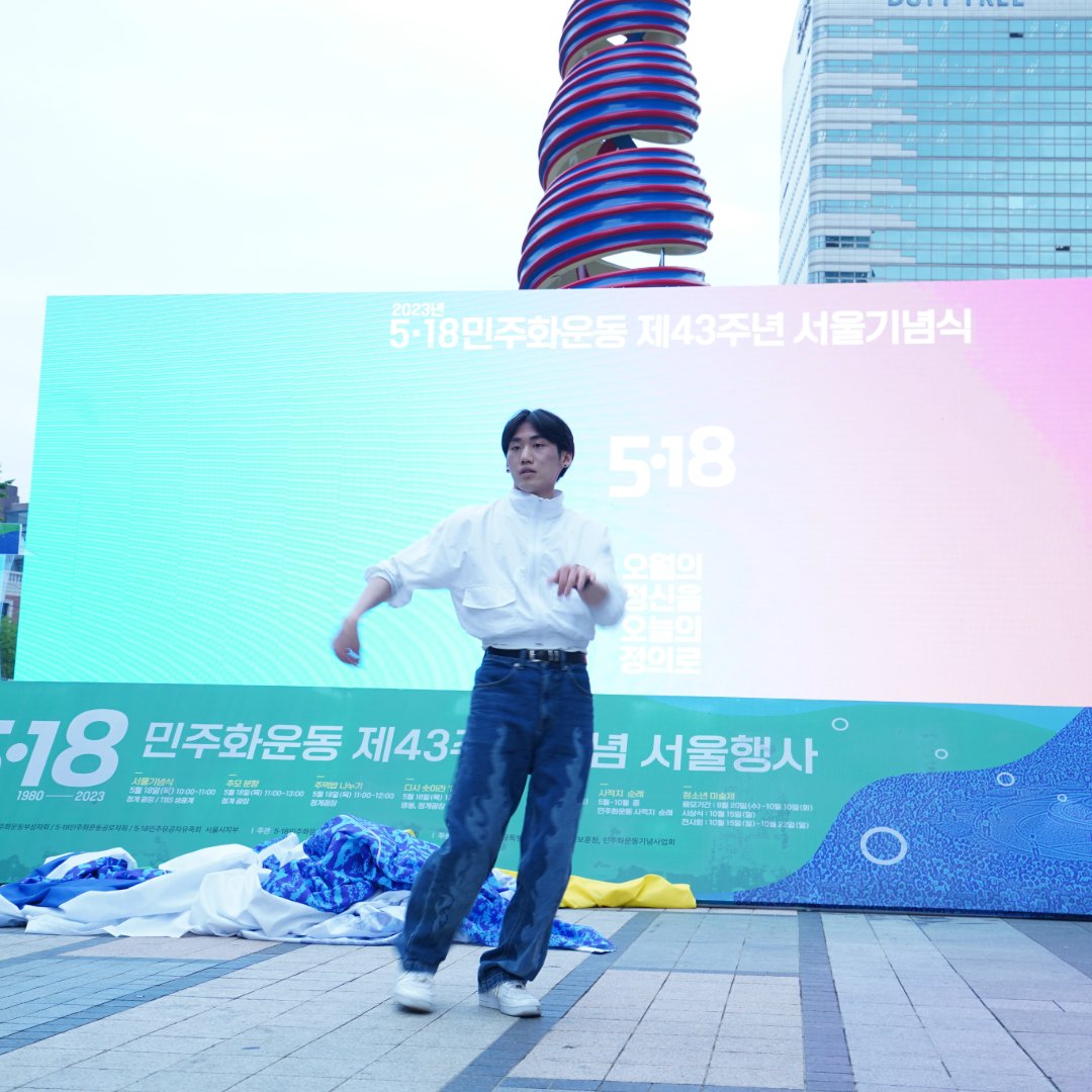 5.18 배경막 앞 무대에서 흰 셔츠를 입은 댄서가 혼자 춤추고 있다