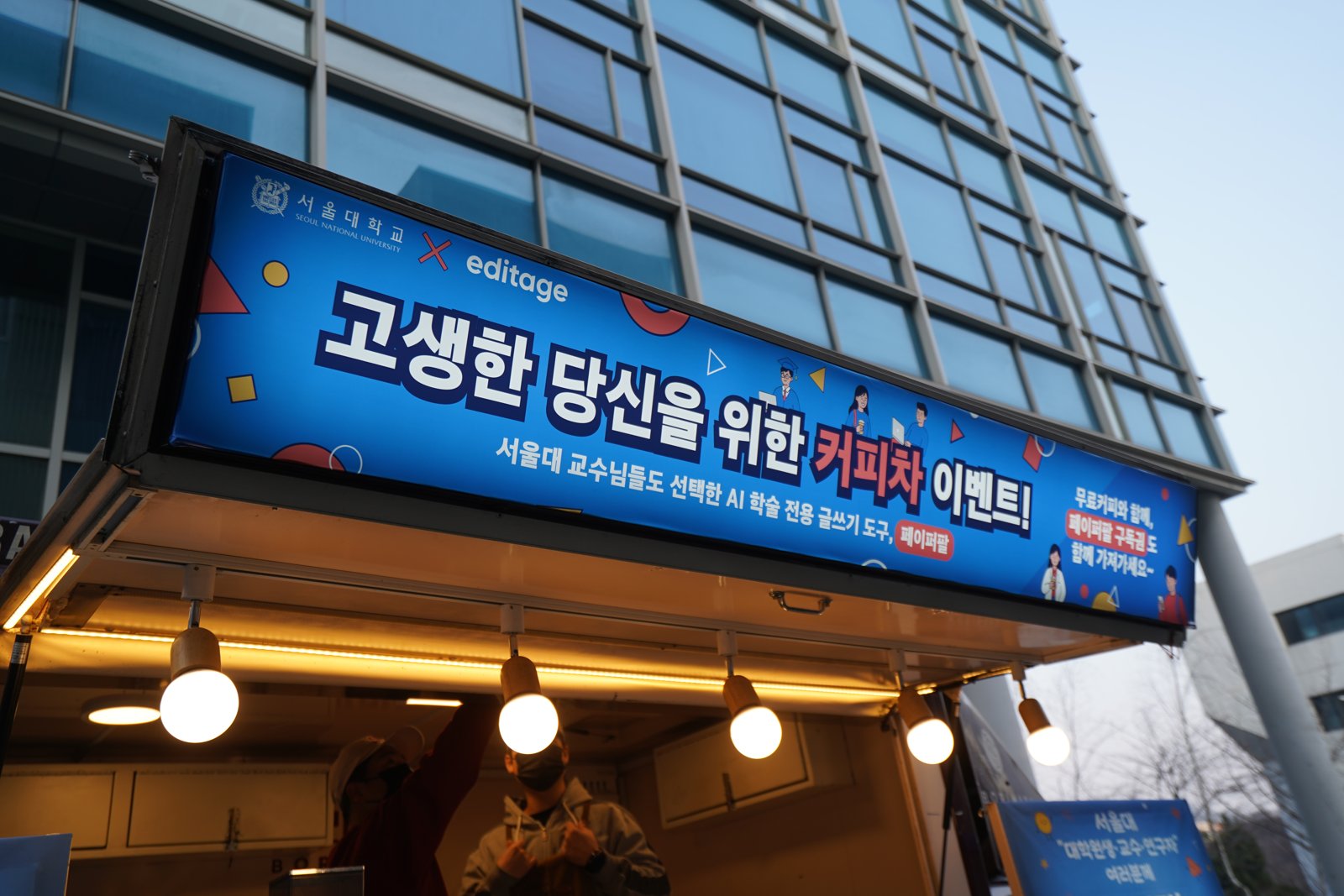 커피차 지붕 위에 서울대학교와 에디티지 로고, 고생한 당신을 위한 커피차 이벤트 문구, 페이퍼팔 구독권 안내를 넣은 파란 현수막이 걸려 있다